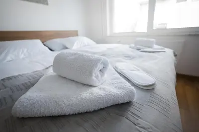 a white towel is sitting on a bed at Apartma Lida 1- mirna lokacija, brezplačno parkirišče, 10 minut hoje do jezera in gradu in Bled