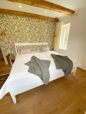 a white bed in a bedroom with a wall at Historical Villa in the heart of Bled 2 in Bled