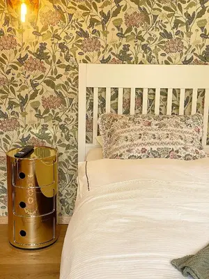 a bedroom with a bed with a white bedspread and floral wallpaper at Historical Villa in the heart of Bled 2 in Bled