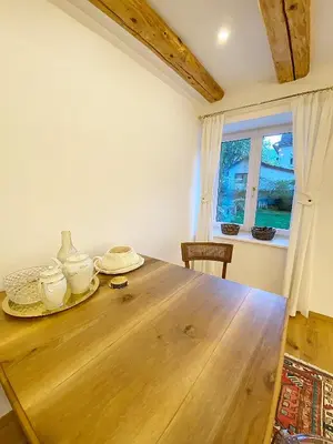 a dining room with a wooden table and a window at Historical Villa in the heart of Bled 2 in Bled