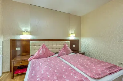 a bedroom with a pink bed with pink pillows at Pool Villa Silva Marija Apartments in Pišece
