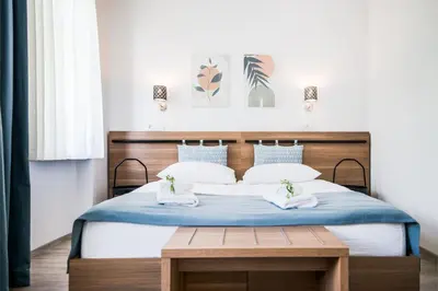 a bedroom with a large bed with blue and white pillows at B&B Pod vrbo in Ljubljana