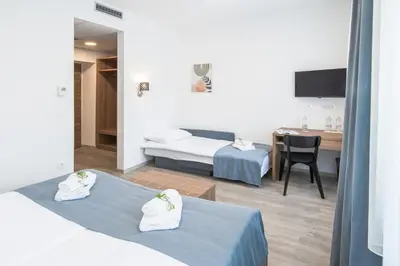 a hotel room with two beds and a dining room at B&B Pod vrbo in Ljubljana