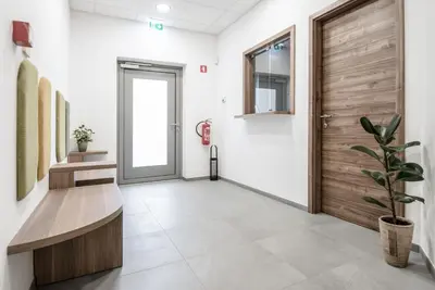 an office corridor with a wooden door and a potted plant at B&B Pod vrbo in Ljubljana