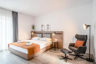 a hotel room with a bed and a chair at B&B Pod vrbo in Ljubljana