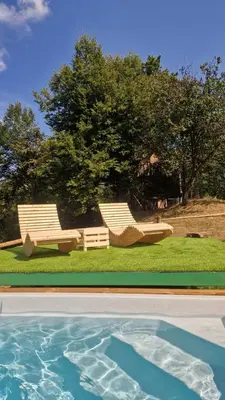 two chairs and a swimming pool in a yard at Treehouse Toplak in Ruše