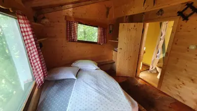 a small room with a bed in a cabin at Treehouse Toplak in Ruše