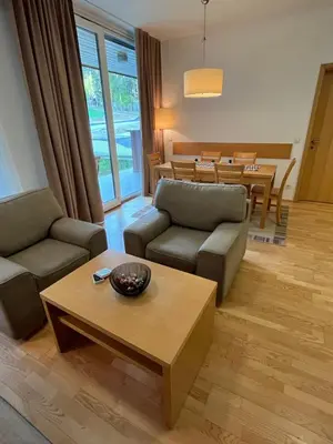 a living room with two couches and a table at Golden Fox Apartment Pohorje in Maribor