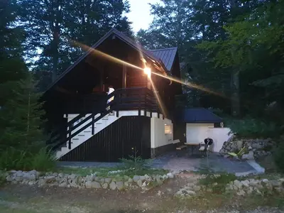 a log cabin with the sun shining on the side of it at ARIA in Sviščaki
