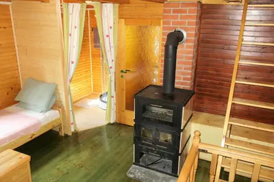 a wood stove in a room with a bed at ARIA in Sviščaki