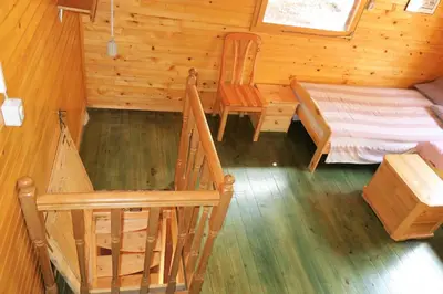 a bedroom with a bed and a chair in a cabin at ARIA in Sviščaki