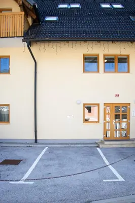 an empty parking lot in front of a building at Apartma Sonček, on the ski slopes, balcony, private parking in Kranjska Gora