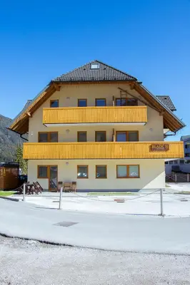 a large building with yellow balconies on top of it at Apartma Sonček, on the ski slopes, balcony, private parking in Kranjska Gora
