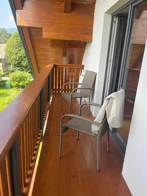 a balcony with two chairs on a wooden deck at Hiša Višnar in Bled