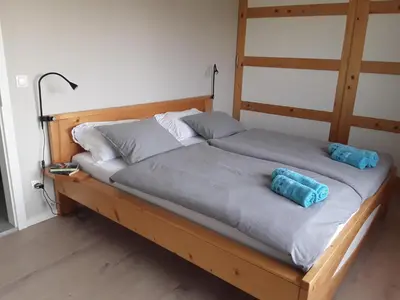 a bed with two blue pillows on top of it at Hiša Višnar in Bled