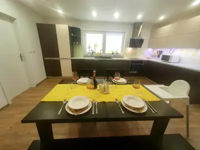 a table with plates and glasses on it in a kitchen at Apartma DAVID in Zgornje Gorje