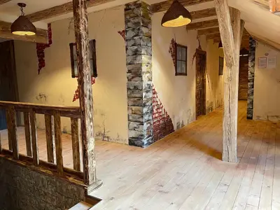 an empty room with a stone wall and wooden floors at Vamiš in Gornji Petrovci