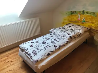 a bed in a room with a painting on the wall at Vamiš in Gornji Petrovci