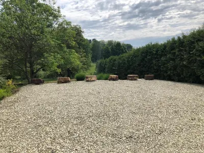 a large gravel field with wooden benches in it at Vamiš in Gornji Petrovci