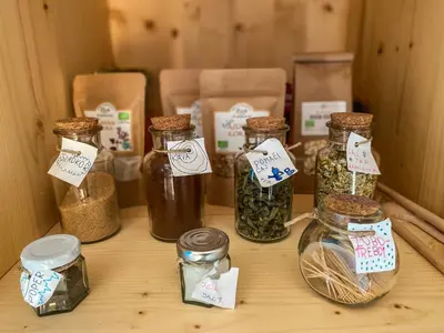 a table with jars filled with herbs and spices at Wellness hiška Robida in Ljutomer