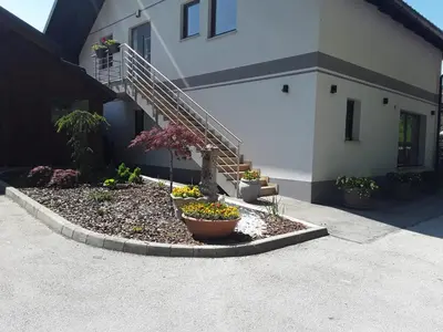 a building with a staircase and flowers in a yard at Apartmaji Tisa in Žana in Rovte