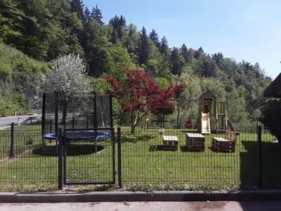a fence with a playground in a park at Apartmaji Tisa in Žana in Rovte