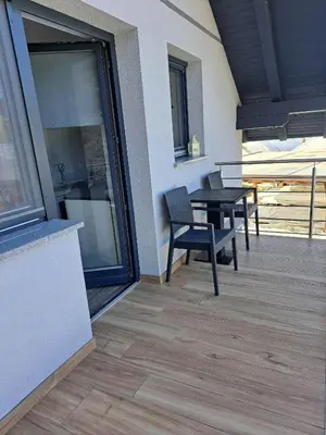 a patio with a table and chairs on a balcony at Apartmaji Tisa in Žana in Rovte