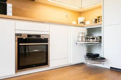 a kitchen with white cabinets and an oven at APARTMENT 396 in Ljubljana