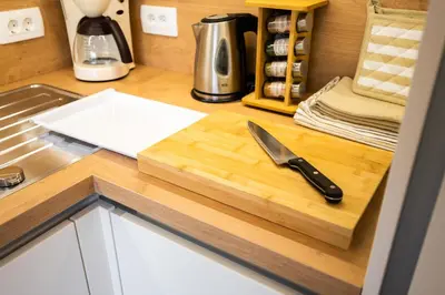 a knife on a wooden cutting board on a kitchen counter at APARTMENT 396 in Ljubljana