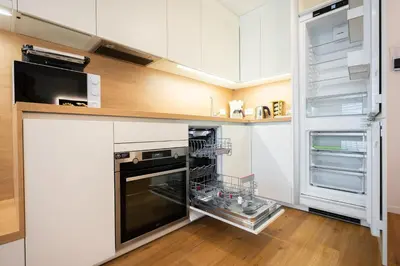 a kitchen with an oven and an open refrigerator at APARTMENT 396 in Ljubljana