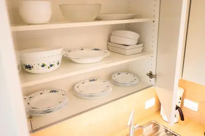 a cupboard with plates and bowls in it at APARTMENT 396 in Ljubljana