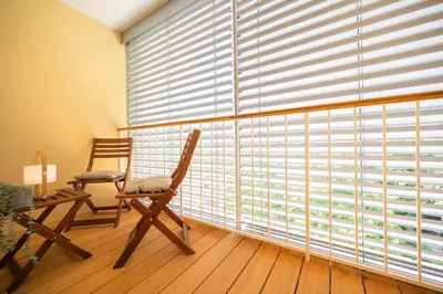 a room with two chairs and a large window with blinds at APARTMENT 396 in Ljubljana