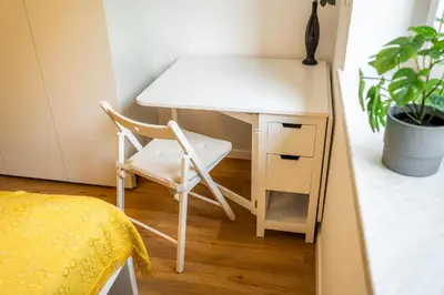 a white desk with a chair next to a table at APARTMENT 396 in Ljubljana