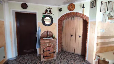 a room with a door and a brick fireplace at Apartman Vesna in Veliki Vrh