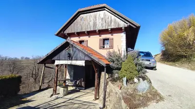 a small house on the side of a road at Apartman Vesna in Veliki Vrh