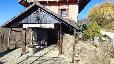 a building with a bench in front of it at Apartman Vesna in Veliki Vrh