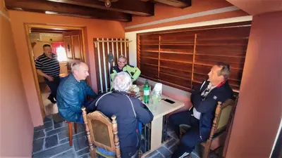 a group of people sitting around a table in a room at Apartman Vesna in Veliki Vrh