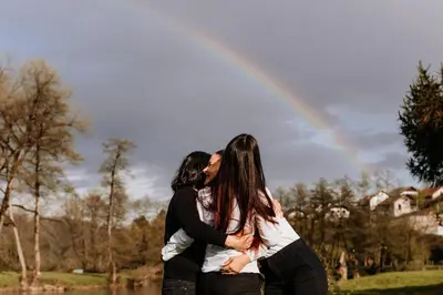 two women kissing in front of a rainbow at Gostišče Koren in Žužemberk