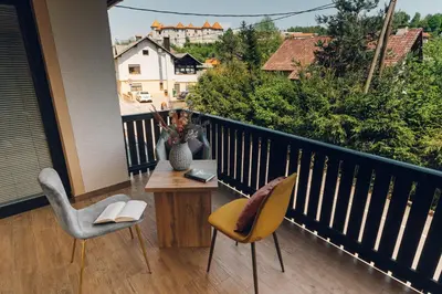 a balcony with two chairs and a table with a book at Gostišče Koren in Žužemberk
