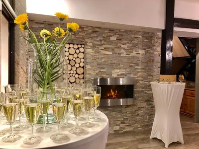 a table with glasses of champagne and a fireplace at Gostišče Koren in Žužemberk