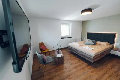 a bedroom with a bed and two chairs at Gostišče Koren in Žužemberk