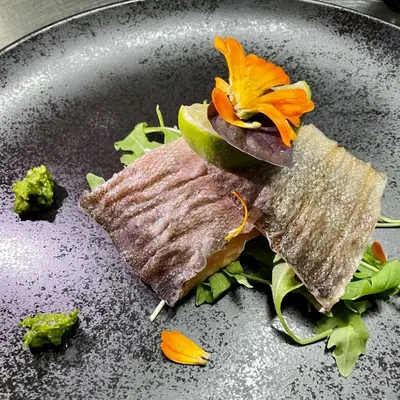 a plate of food with a piece of fish and vegetables at Gostišče Koren in Žužemberk