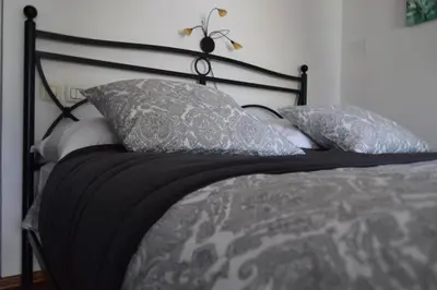 a bed with gray and white pillows on it at Holiday Home Ribno - Bled in Bled