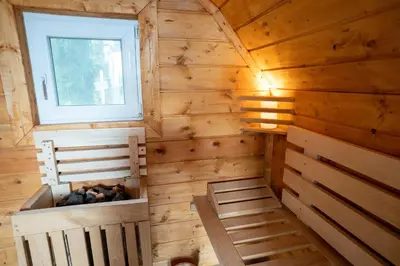 a cabin with wooden walls and a window and two beds at Glamping hišice Orlič in Muta