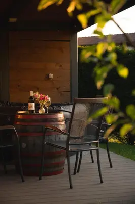 a table and two chairs on a porch with a barrel at Rooms&Vinery Bregovi - Sobe in vinska klet Bregovi in Dobravlje