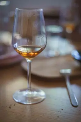 a glass of wine sitting on a wooden table at Rooms&Vinery Bregovi - Sobe in vinska klet Bregovi in Dobravlje