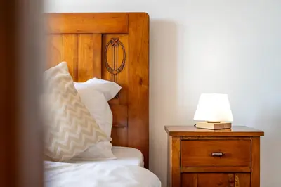 a bedroom with a bed and a lamp on a night stand at Rooms&Vinery Bregovi - Sobe in vinska klet Bregovi in Dobravlje