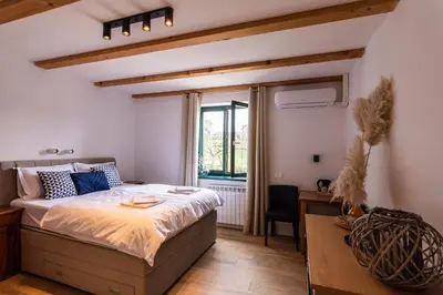 a bedroom with a bed and a desk and a window at Rooms&Vinery Bregovi - Sobe in vinska klet Bregovi in Dobravlje