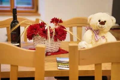 a teddy bear sitting on a table with a bottle of wine at Metropolitana's Zois Apartments in Bohinj