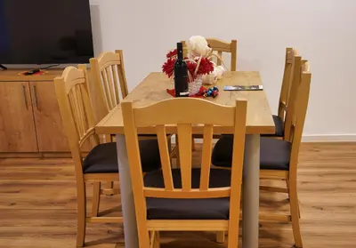 a wooden table with chairs and a vase of flowers on it at Metropolitana's Zois Apartments in Bohinj